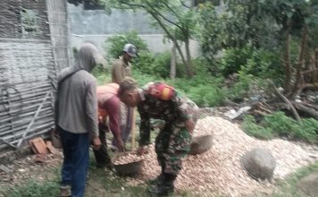 Babinsa Bantu Angkat Material Kerikil untuk Pengerasan Jalan Desa
