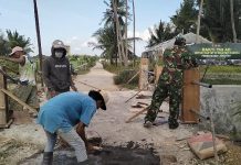Bakti TNI di Kecamatan Lenteng Serka Huda Bersama Warga Laksanakan Pengecoran Tiang Sandaran Jembatan