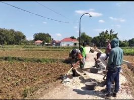 Babinsa Koramil Saronggi Bersama Warga Laksanakan Karya Bakti Pengerasan Jalan